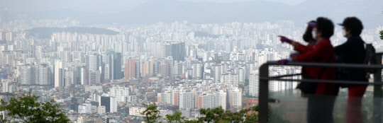 시민들이 서울 남산공원에서 서울 도심 아파트 밀집 지역을 내려다보고 있다. <연합뉴스>